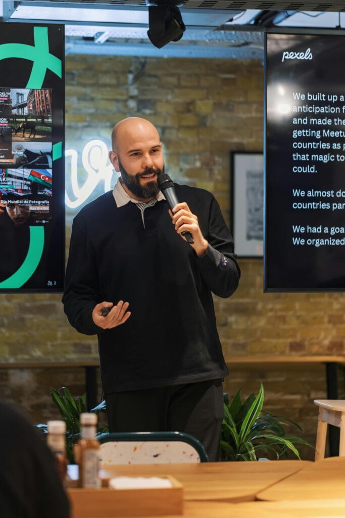 Professional speaker presenting in a modern office with digital screens.